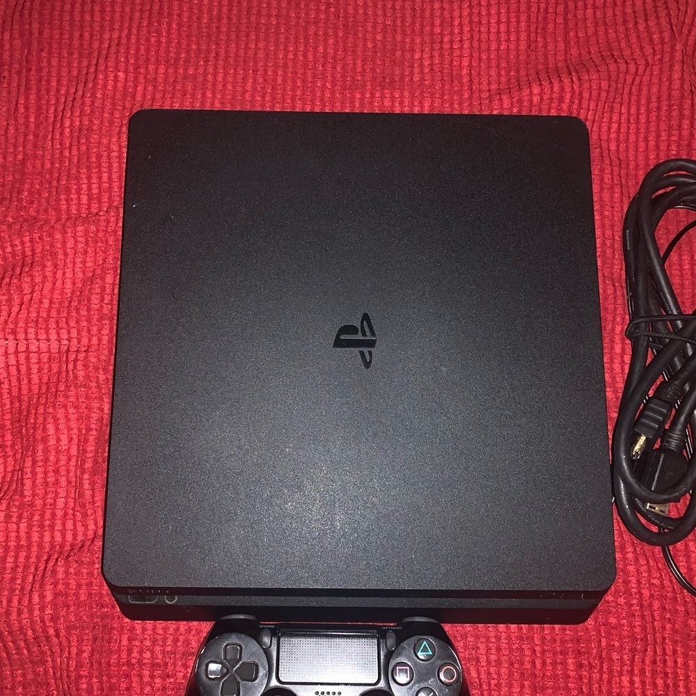 Black PS4 Slim with controller, HDMI cable, and power cords